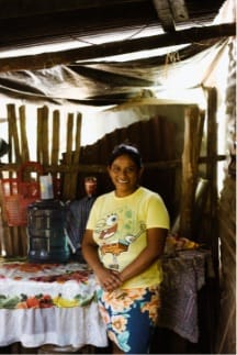 Young woman standing in front of bags of produce
