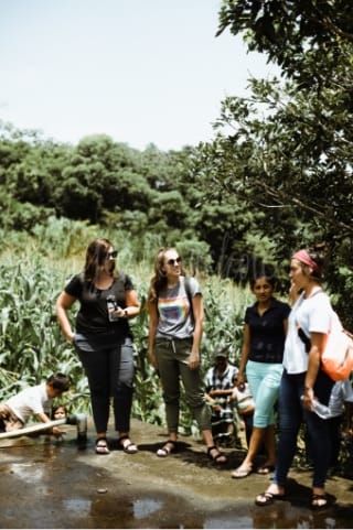 4 women standing outside talking together