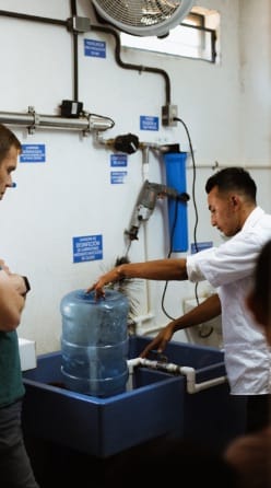 Man cleaning 5-gallon water container in sink